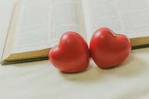 two red hearts and an opened Bible 