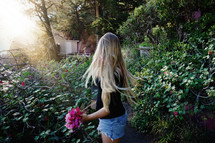 girl picking flowers in a garden 