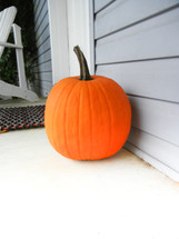 pumpkin on a porch by a door 