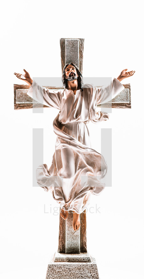 Jesus raised his arms on a crucifix with a bright white background.
