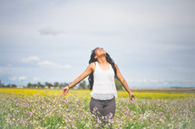 Praising woman in a field of flowers.