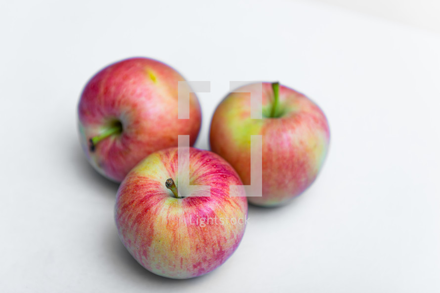 Three rustic apple on a white background