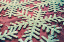 glittery snowflake ornaments on a red background 