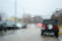 blurry image of parked cars in the rain 