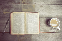 pen, opened Bible, and coffee cup 
