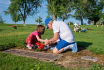 grandfather and granddaughter visiting a grave 