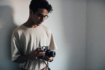 a young man standing holding a camera 