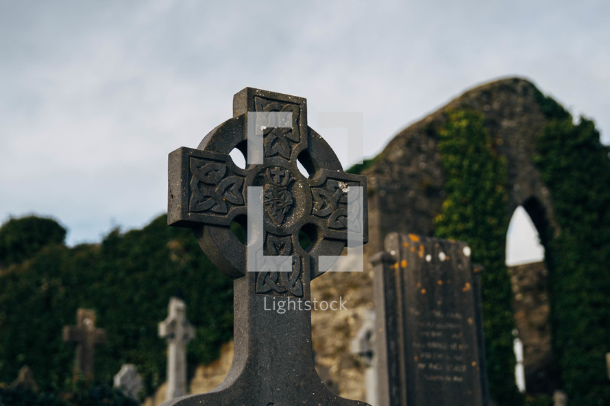 Old Cemetery in Ireland with Celtic Cross Gravestones and Dark Clouds