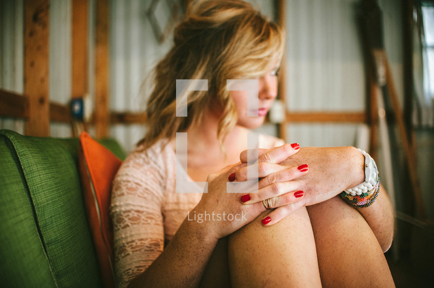 woman sitting in a chair with laced fingers
