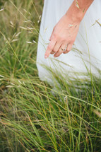 a woman walking through tall grasses 