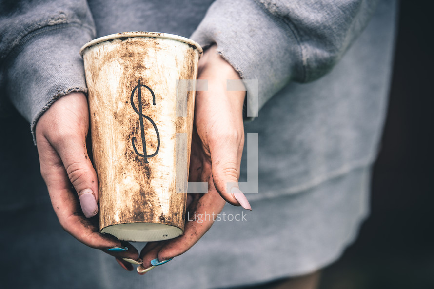 A woman holding a dirty cup with a $ sign 