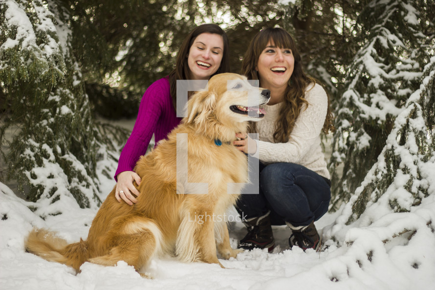 Friends with a dog in the snow.