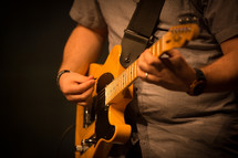 musician on stage playing an electric guitar 