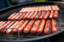 Hot dogs on a grill.