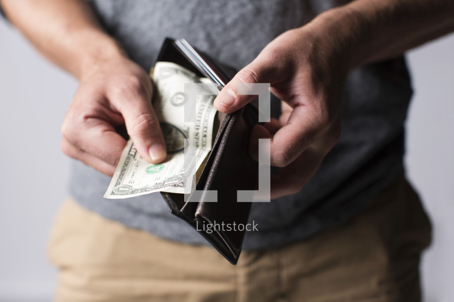 man pulling a dollar out of his wallet 