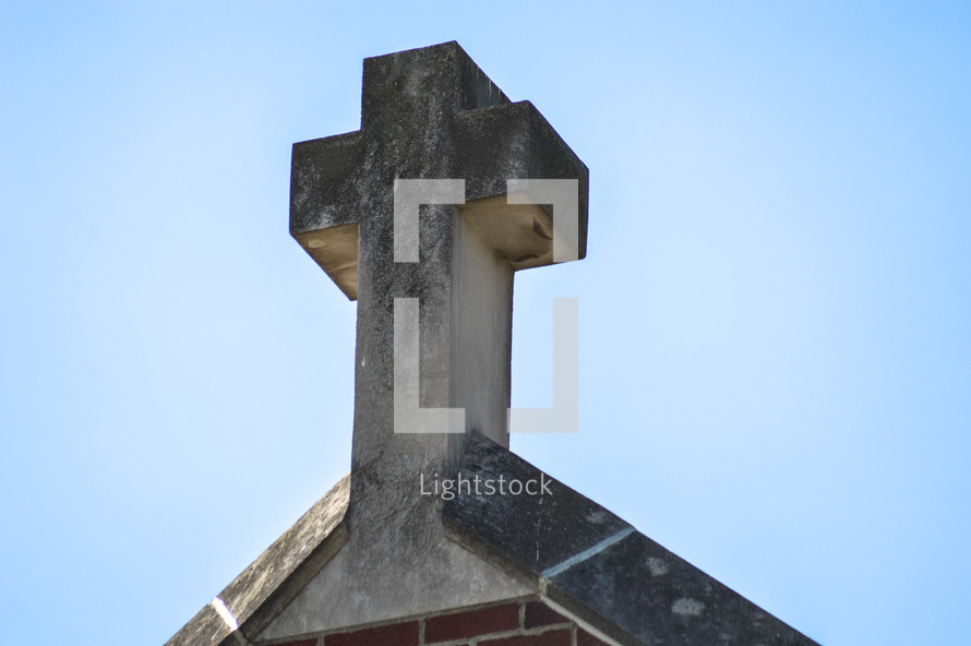 stone cross on a rooftop 