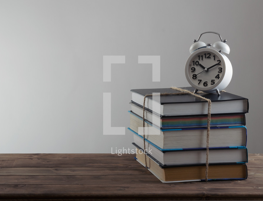 alarm clock on a stack of books