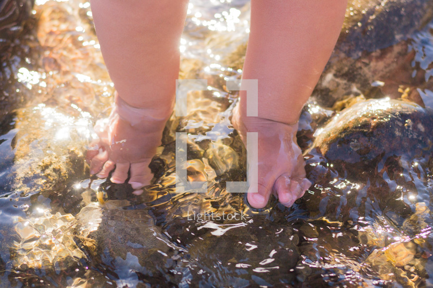 infant feet on wet rocks 