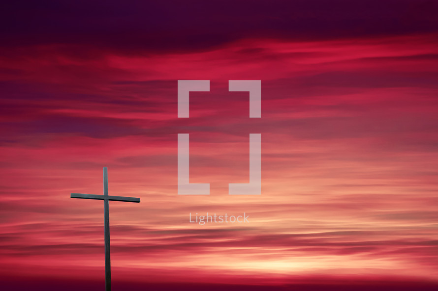 cross against a pink sky at sunset 