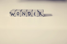 Letter tiles spelling "wonder."
