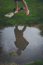 reflection on a boy child in a puddle 