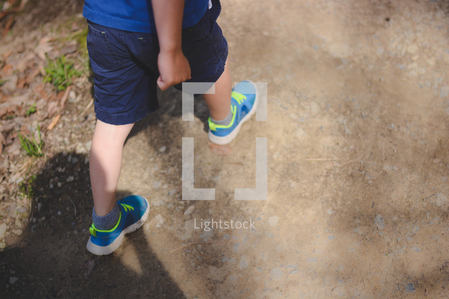 Boy walking on a park trail. 
