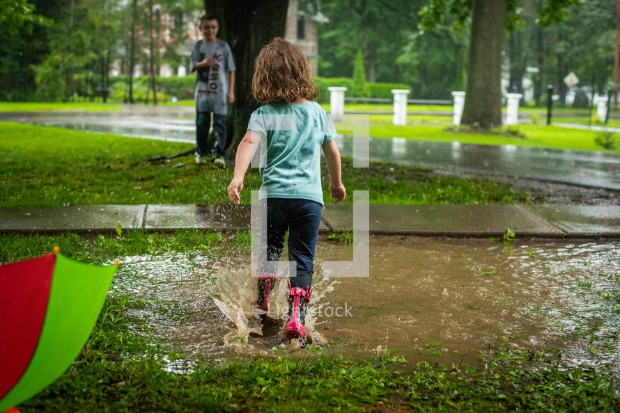 toddler playing in a puddle 