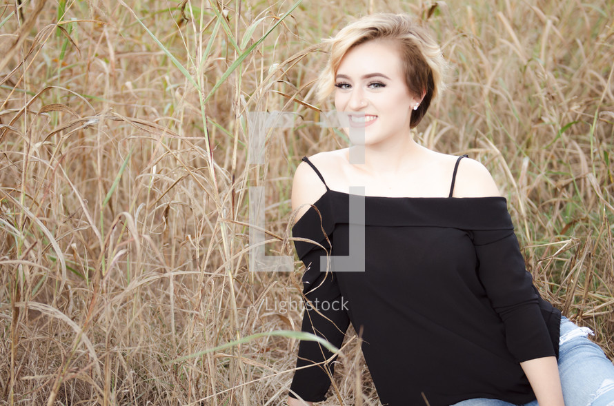 a young woman in a field of tall grass