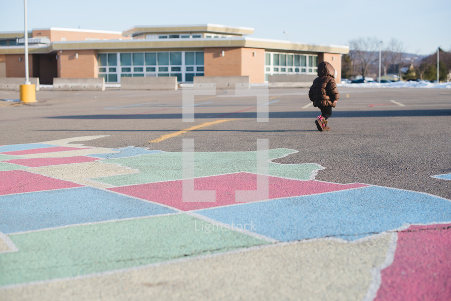 a child walking across a school parking lot 