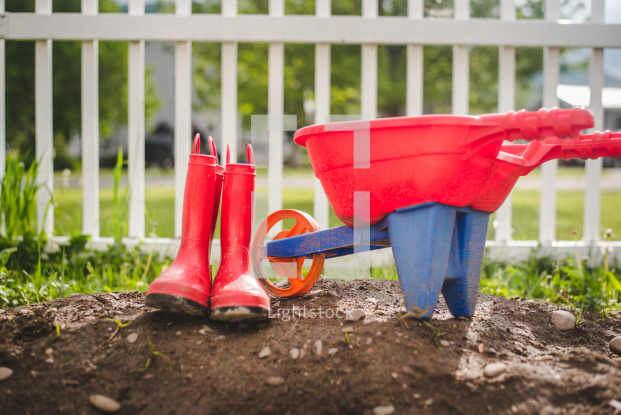 red rain boots and toy wheelbarrow 