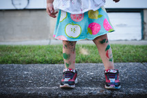 a toddler girl with paint on her legs 