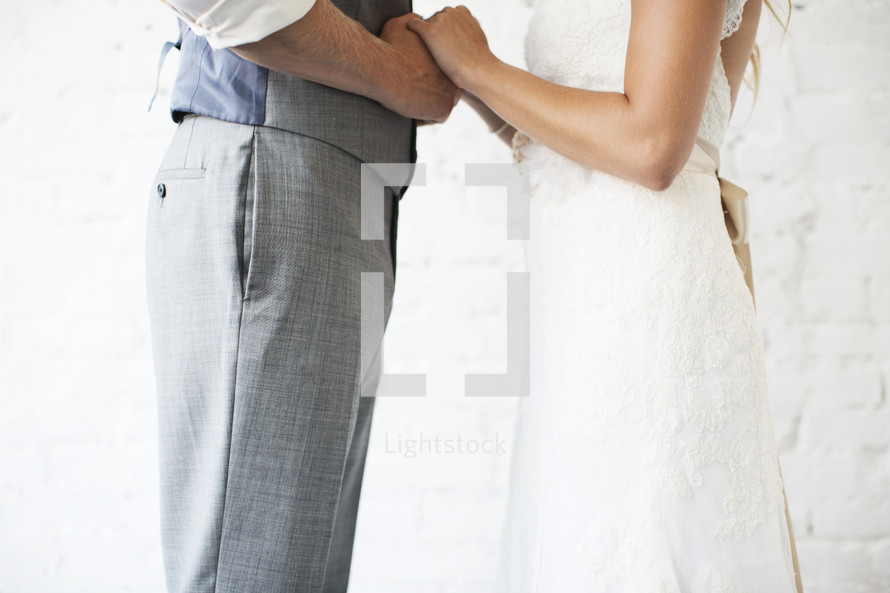 bride and groom holding hands in a portrait 