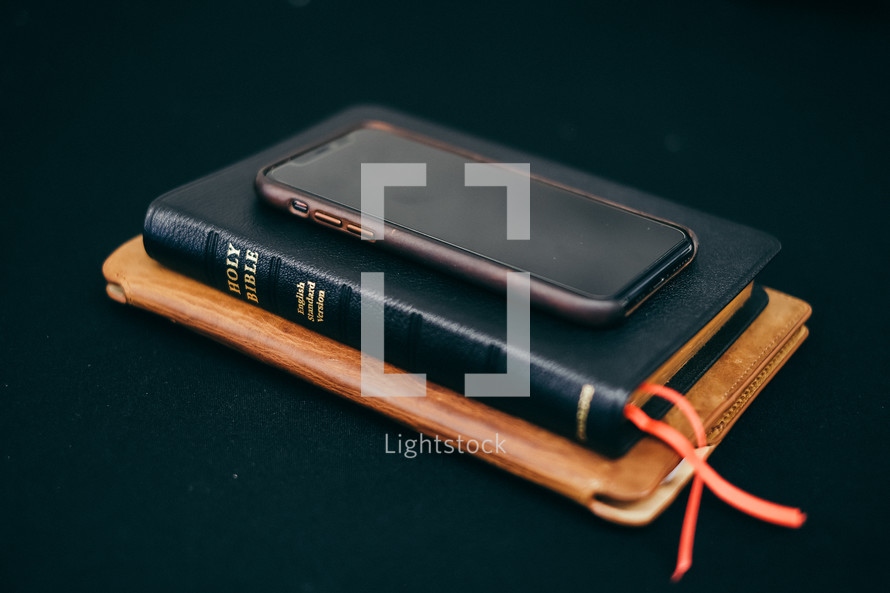 tablet, Bible, and cellphone on a black background 