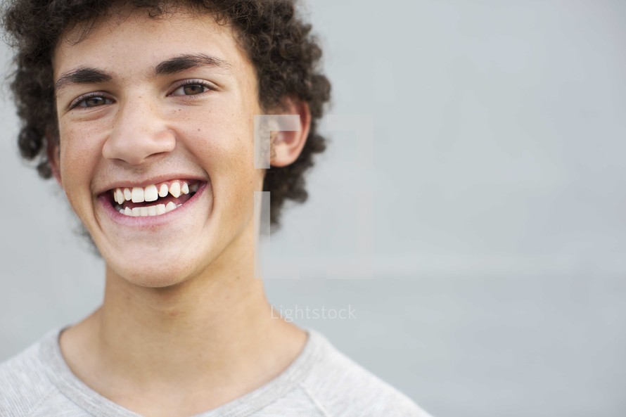 closeup of the face of a smiling teen boy 
