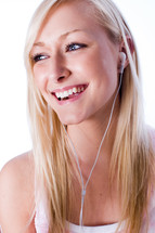 a young woman smiling while listening to music
