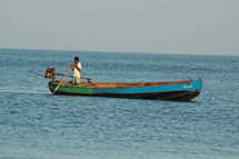 a man paddling a boat in shallow water 