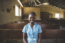 Smiling girl sitting in a church pew.