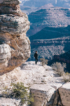 man standing at the edge of a mountain cliff 