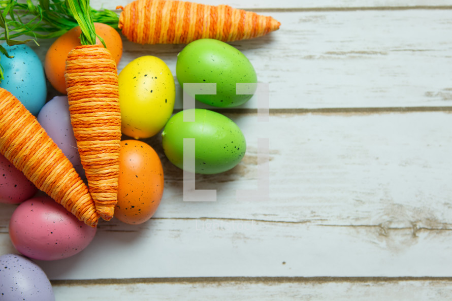 Easter eggs and carrot decorations on wood 