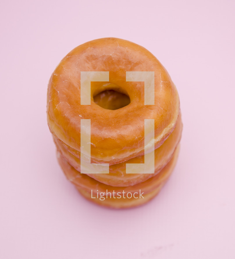 stacked donuts on a pink background 