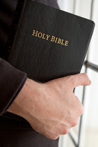 hand holding a Holy Bible
