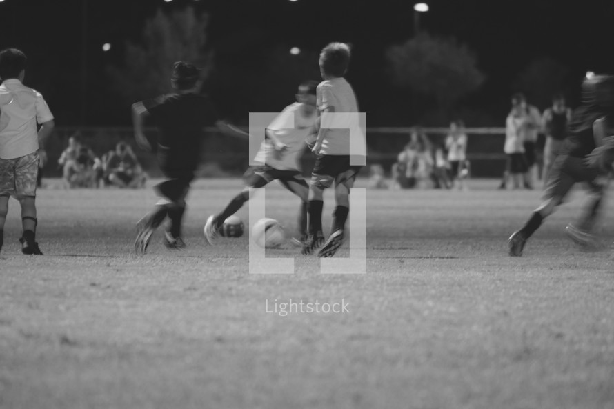 boys kicking a soccer ball during a game 