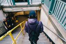 man walking down steps into a subway 