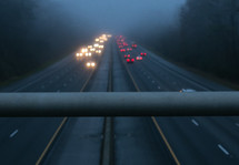 looking down at traffic in fog from a bridge 