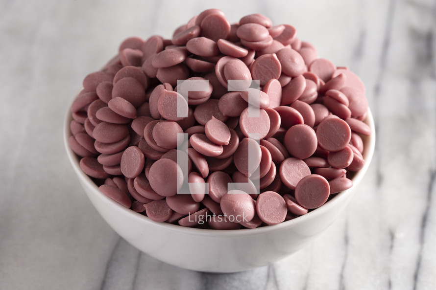 bowl of Authentic Ruby Chocolate Drops on a Marble Counter
