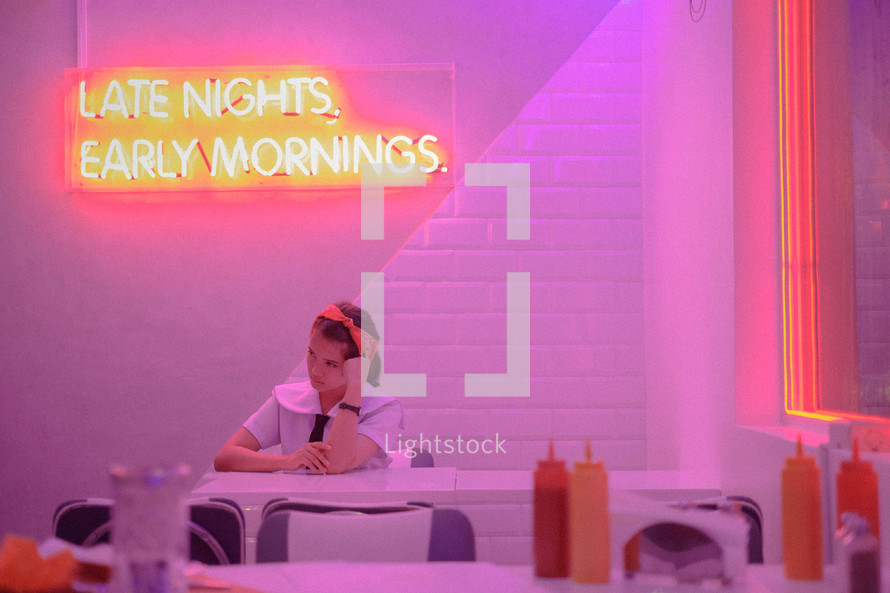 woman sitting in a dinner, late nights early mornings 
