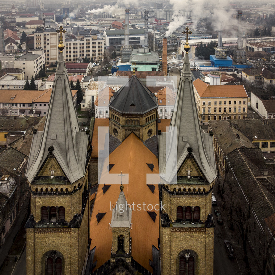 aerial view over a cathedral and smokestacks 