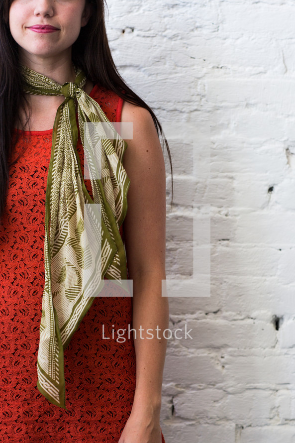 torso of a woman in gold scarf 