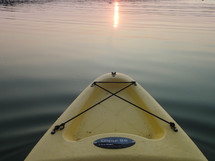 yellow kayak in a lake at sunset