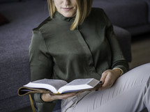 a woman sitting on the floor reading a Bible 